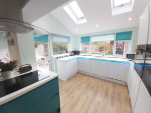 Colour coordinated roller blinds fitted in a kitchen